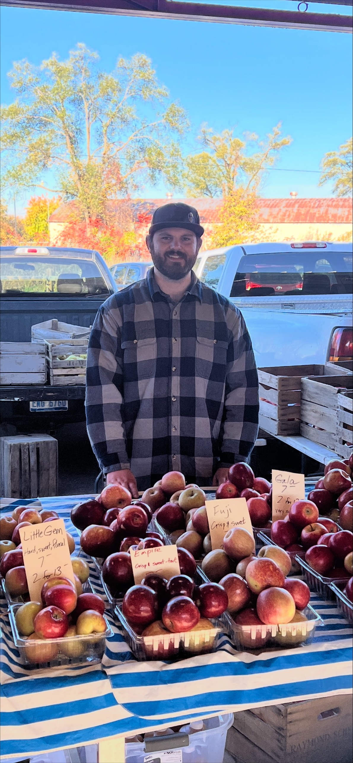 Daniel Dick standing outdoors among fruit trees